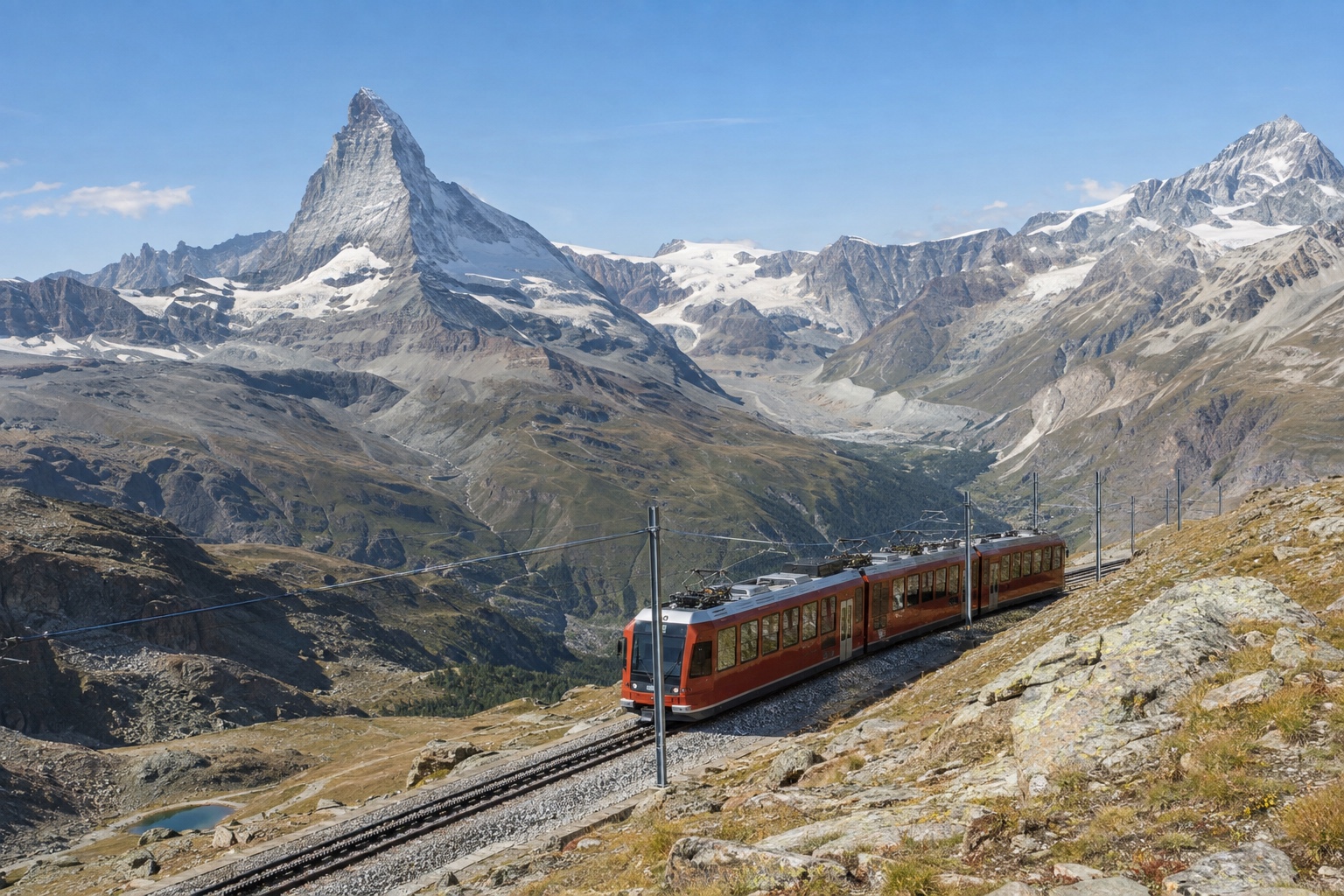 Gornergrat cogwheel railway train ascending with the Matterhorn visible across the valley